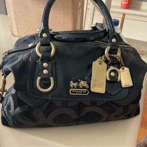 Coach Madison's black satchel has three tags and is in EUC